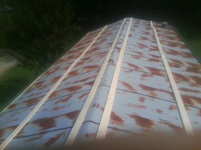 Rusted metal roof panels with new wood purlins before replacement — Storm Damage Roof Repair in Algonac by Roofing Brothers