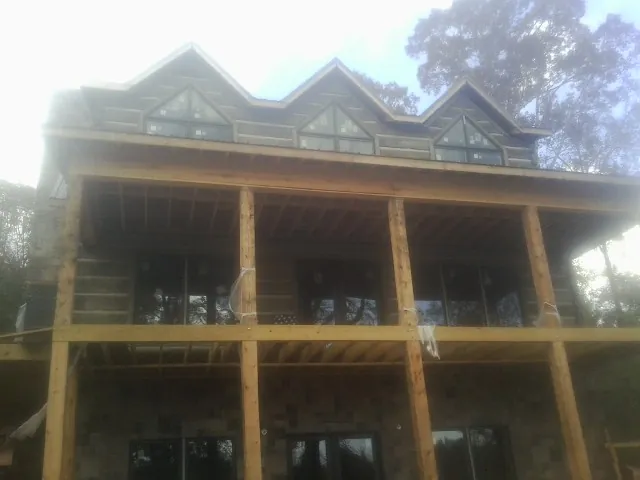 Dormers and porch framing on a large log home under construction — Roof Coating work by our crew in Algonac